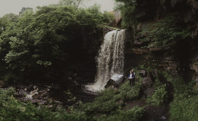 Couple standing beside a hidden waterfall couple portrait session