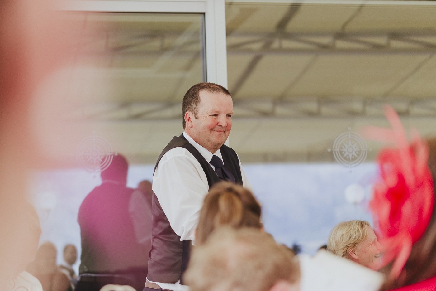 Man in waistcoat standing up and reflection on glass by Joshua Wyborn
