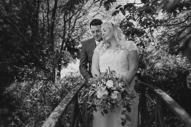 A bride and groom exchanging vows on a picturesque bridge enveloped by the enchanting woods during their wedding at Augill Castle.