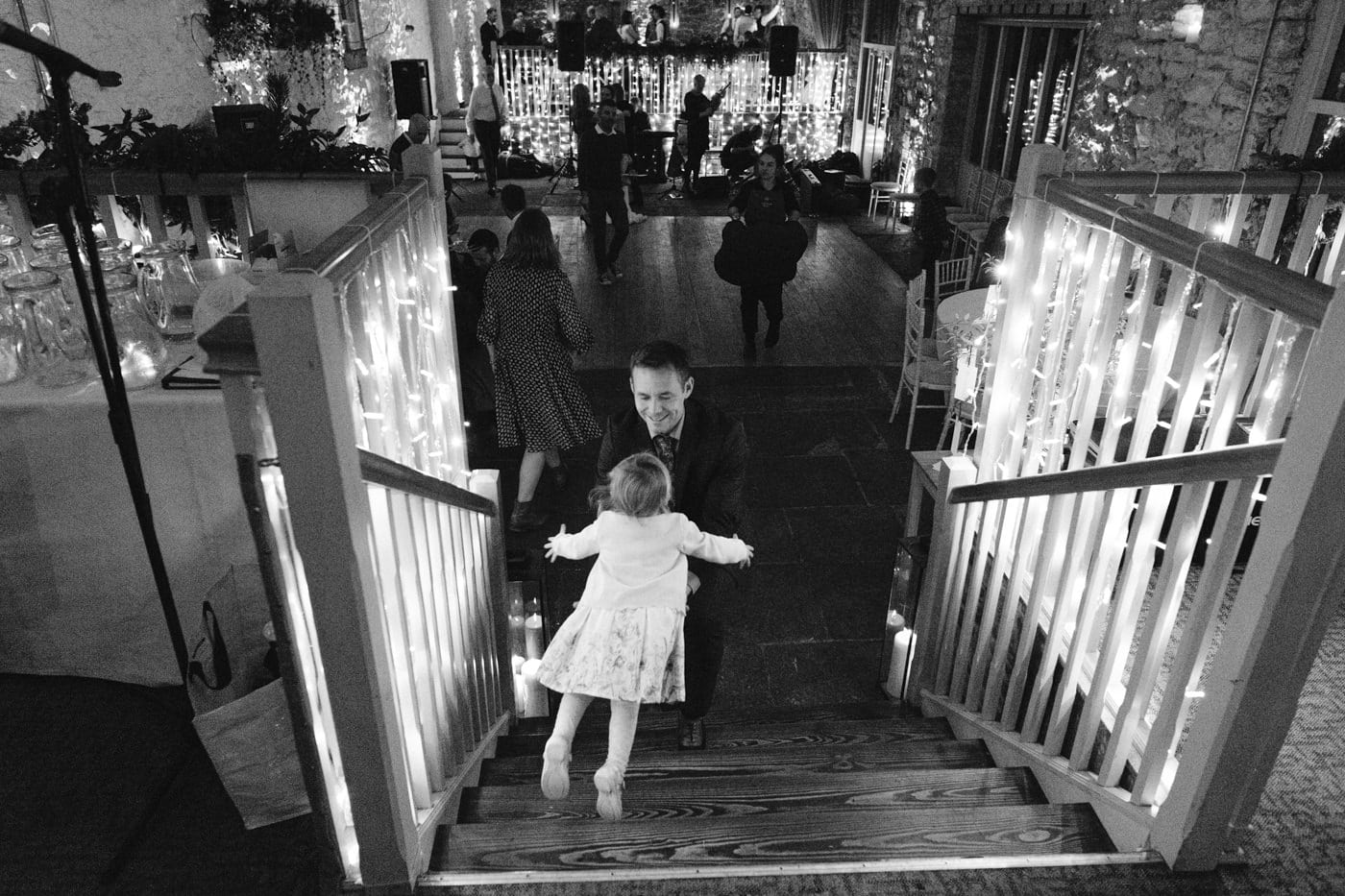 A little girl is walking up the stairs at Askham Hall wedding.