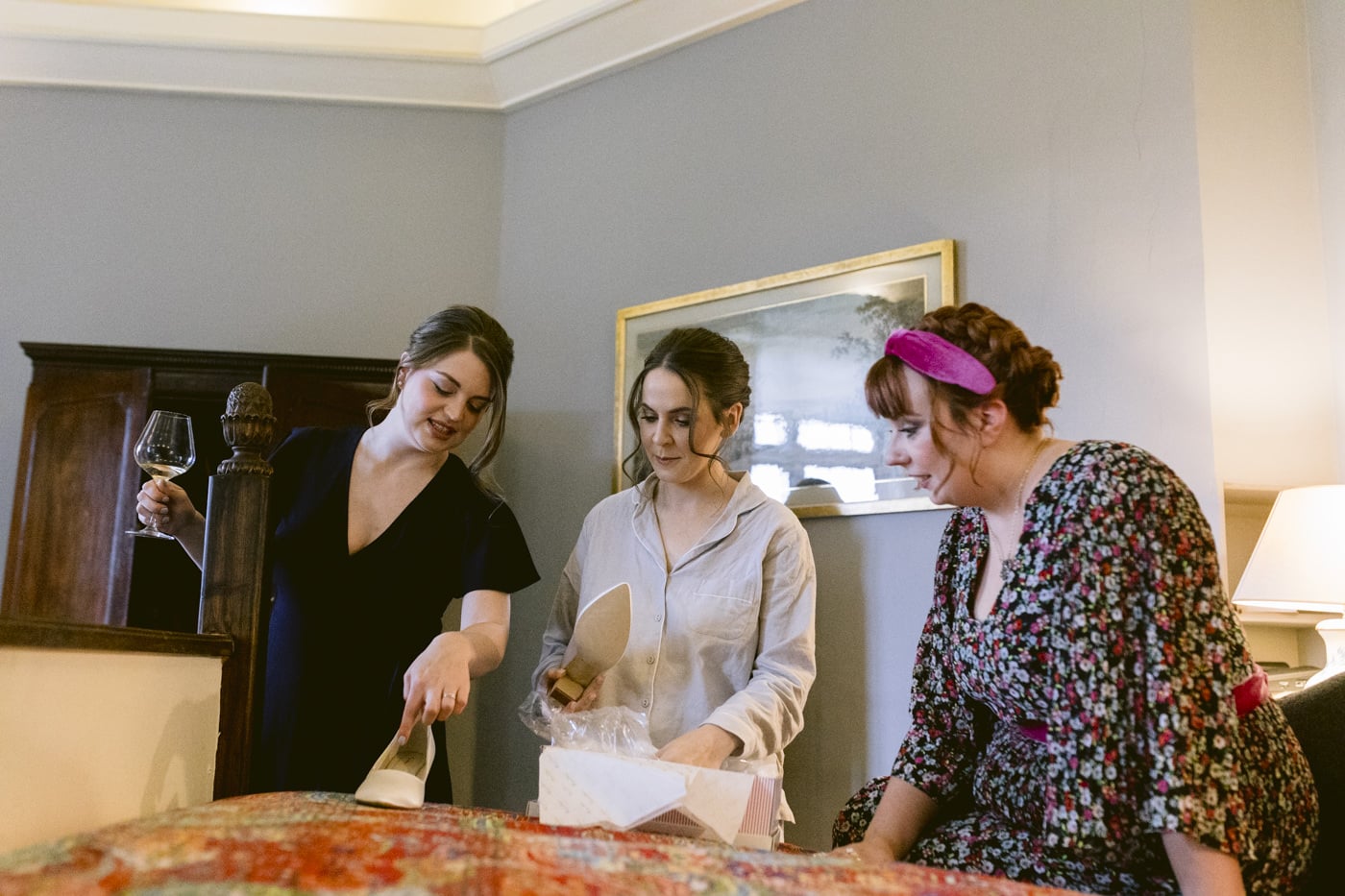 Three women standing in a room at Askham Hall looking at a bed.
