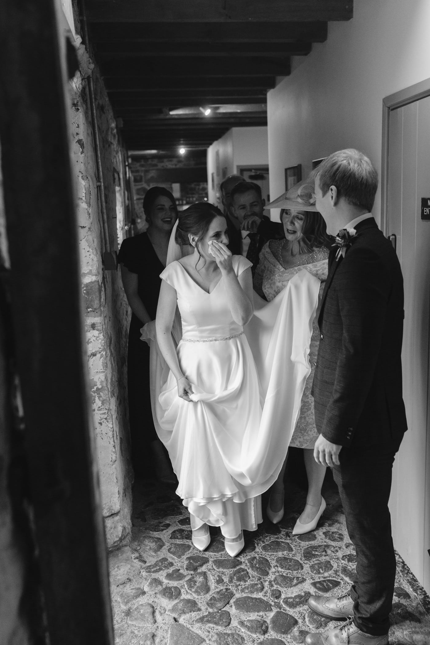 A bride is walking down a hallway at Askham Hall with her bridesmaids.