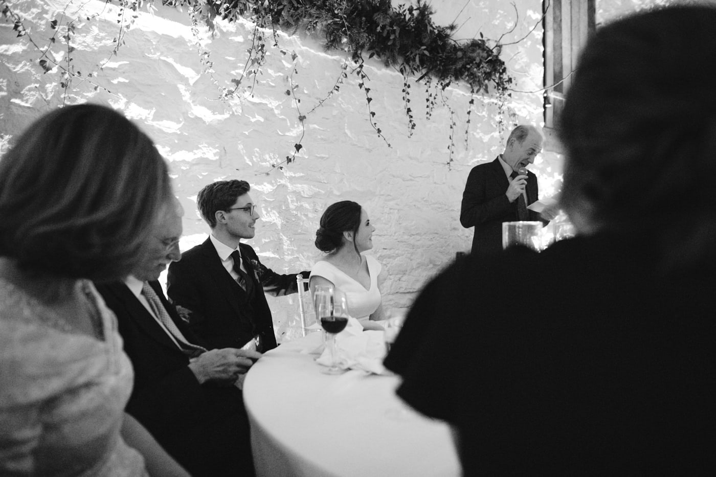 A black and white photo of a man giving a speech at Askham Hall wedding.