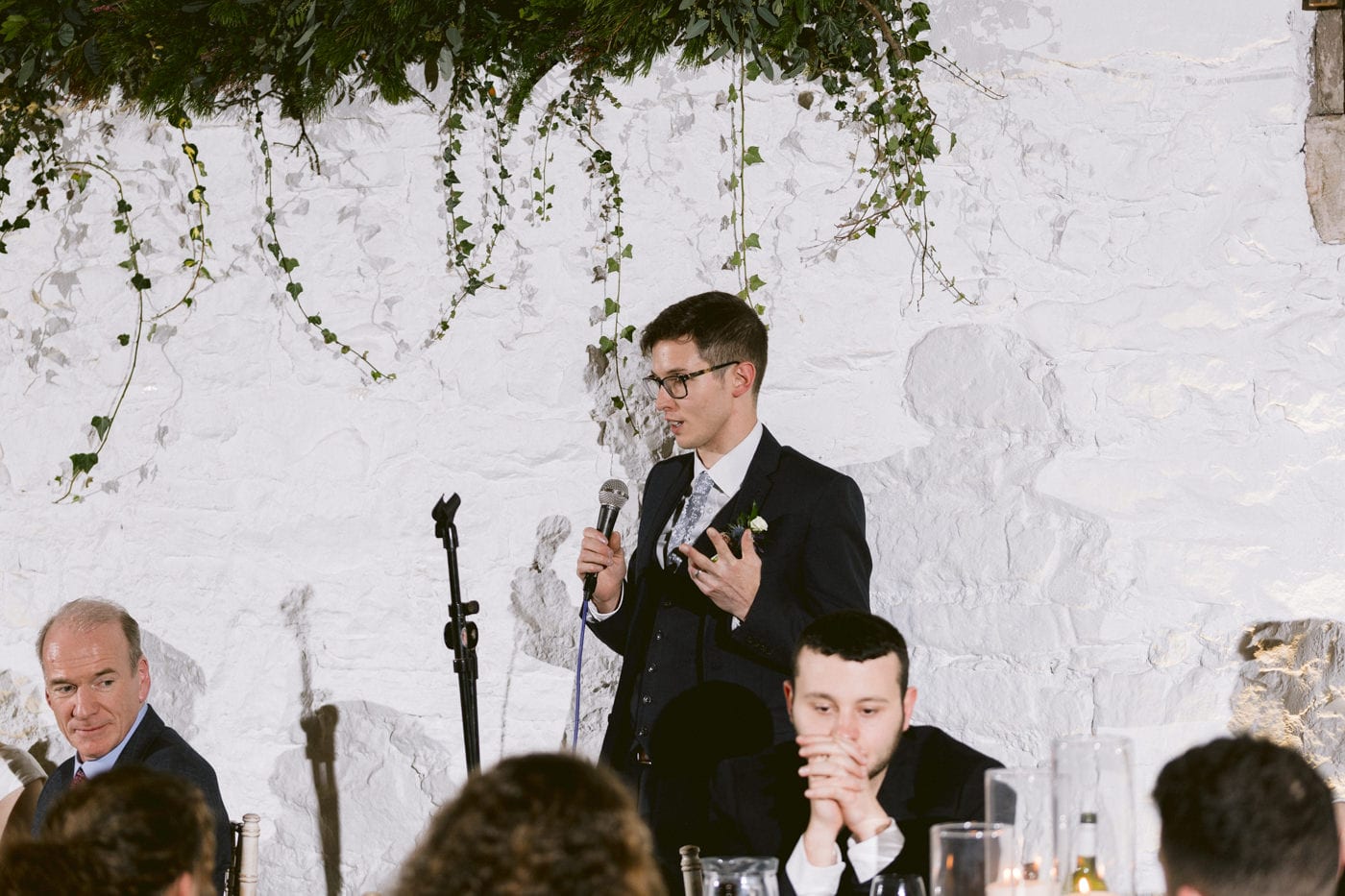 A man giving a speech at a wedding reception held in Askham Hall Bank Barn.