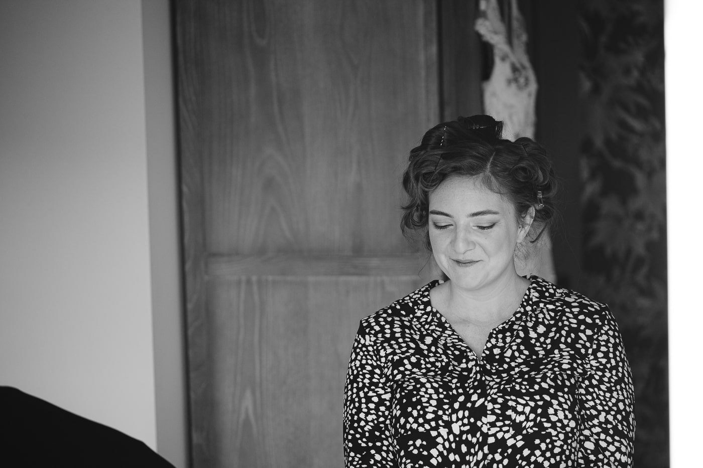 A black and white photo of a woman getting ready for her Hexham House wedding.