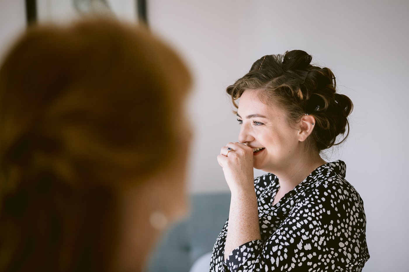 A Hexham House bride getting ready in front of a mirror.