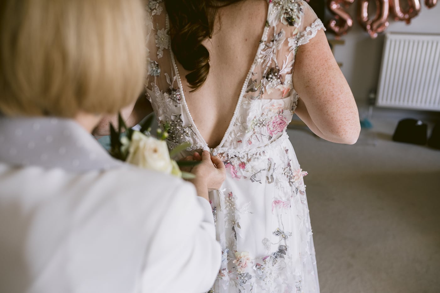 A Hexham House bride elegantly donning her wedding dress.