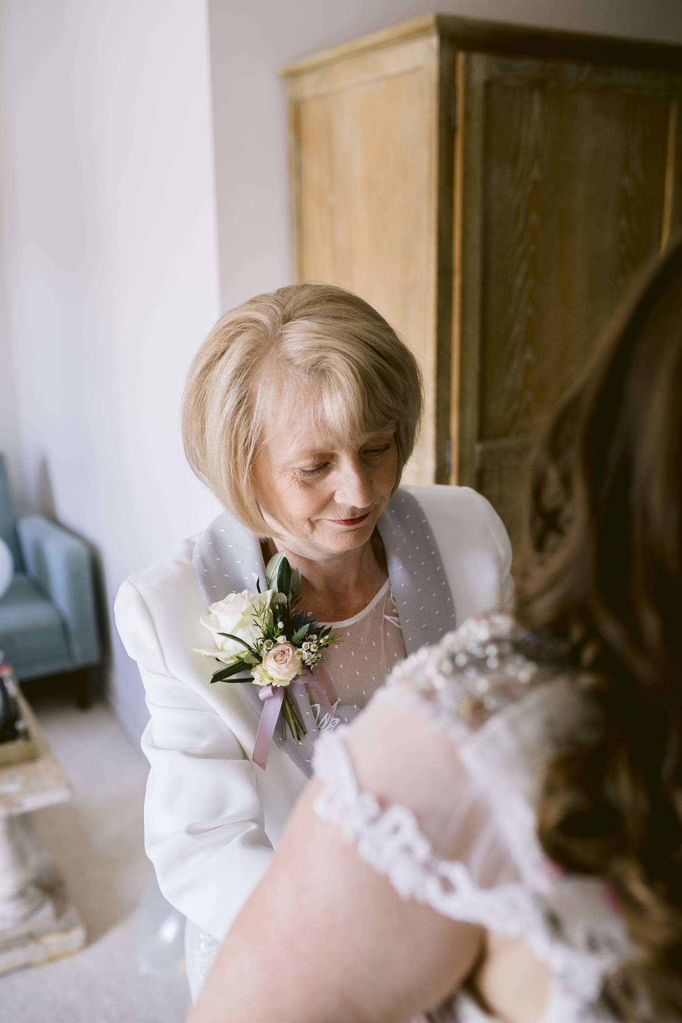An older woman helping her daughter prepare for her Hexham House wedding.