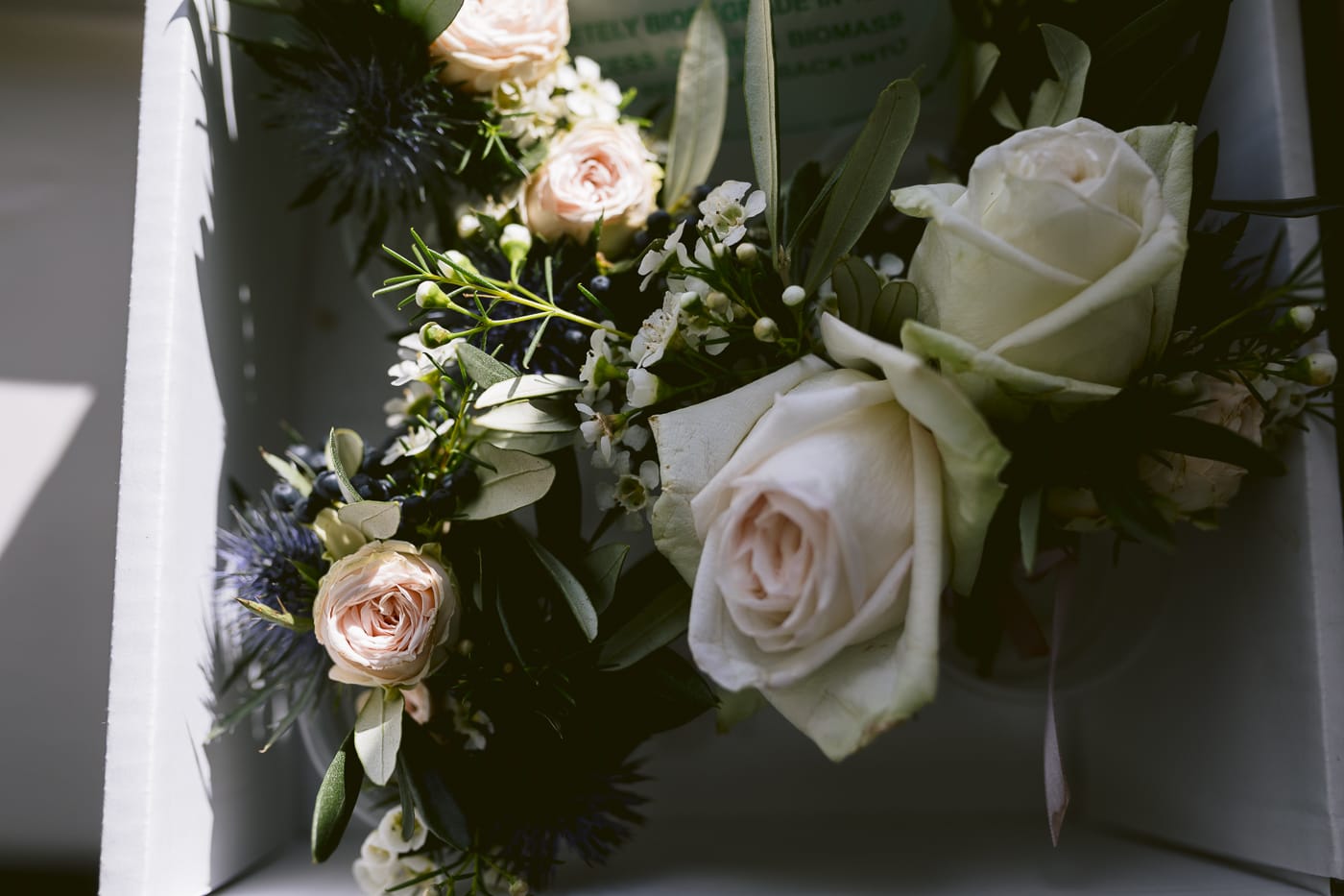 A Hexham House Wedding bouquet of roses and greenery in a box.