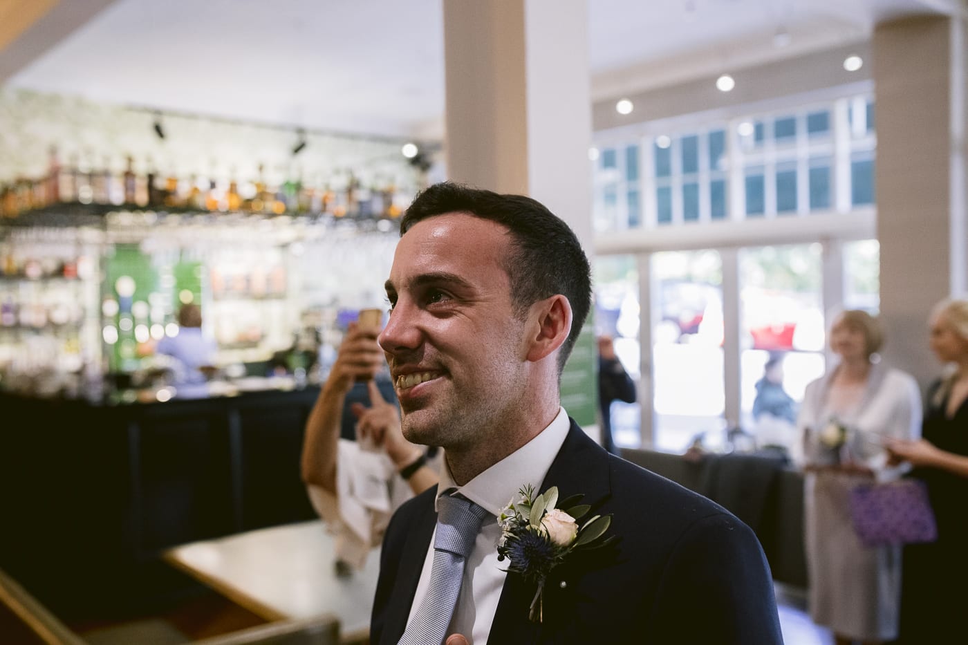 A man in a suit smiles as he enters Hexham House.