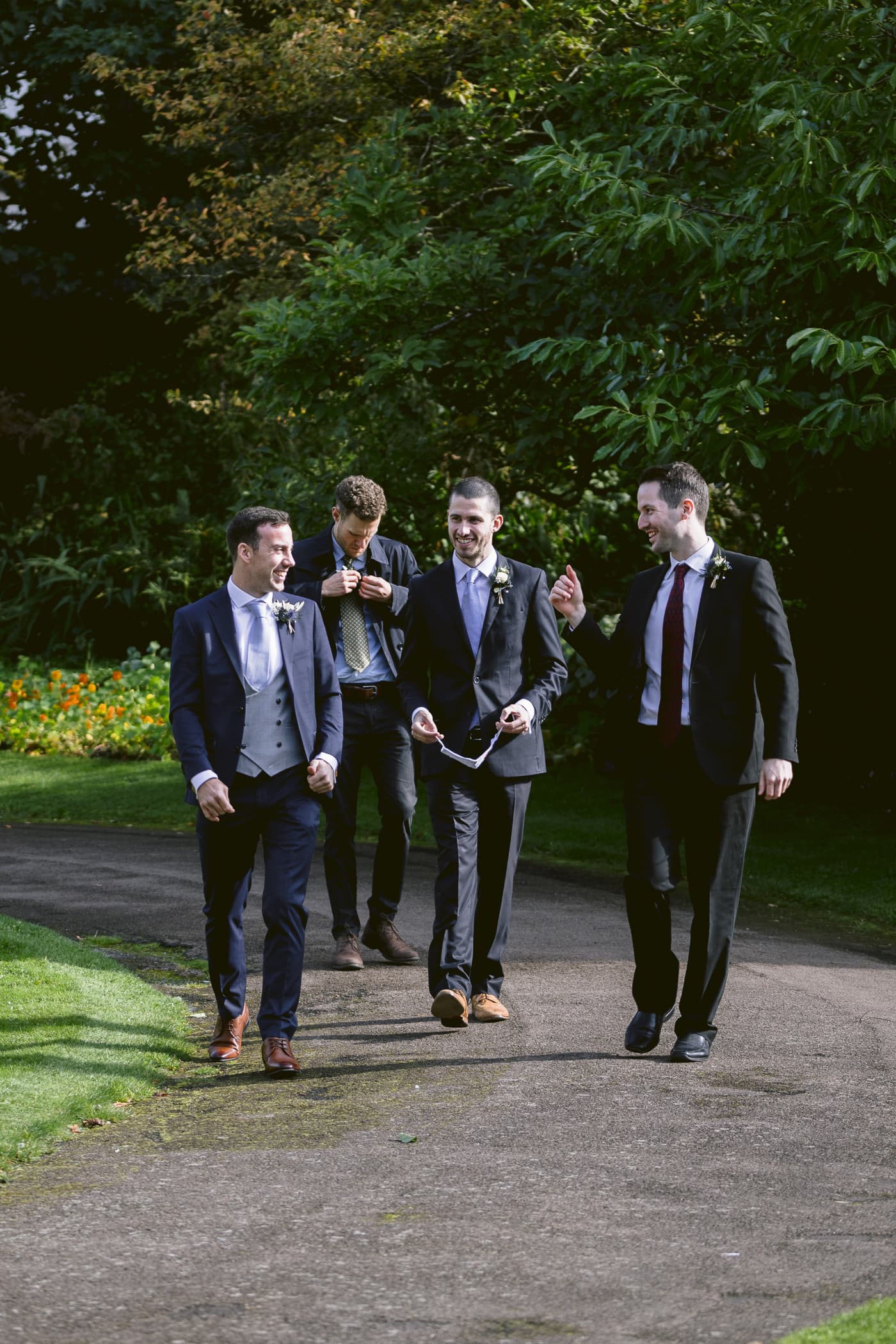 Groomsmen at Hexham House Wedding walking down a path.