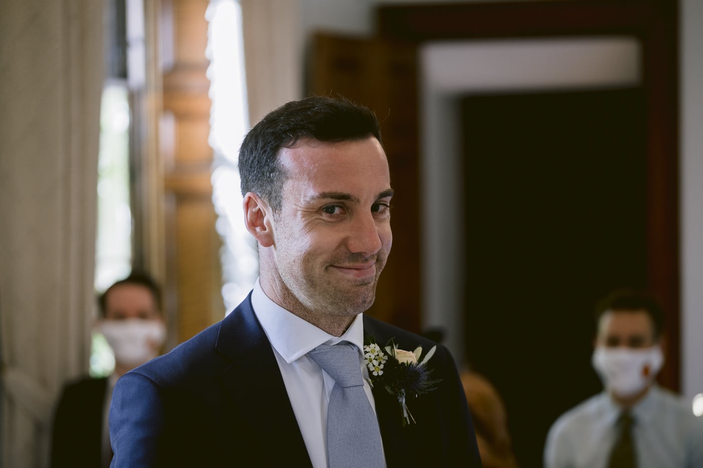 A man in a suit smiles as he walks down the aisle at Hexham House Wedding.