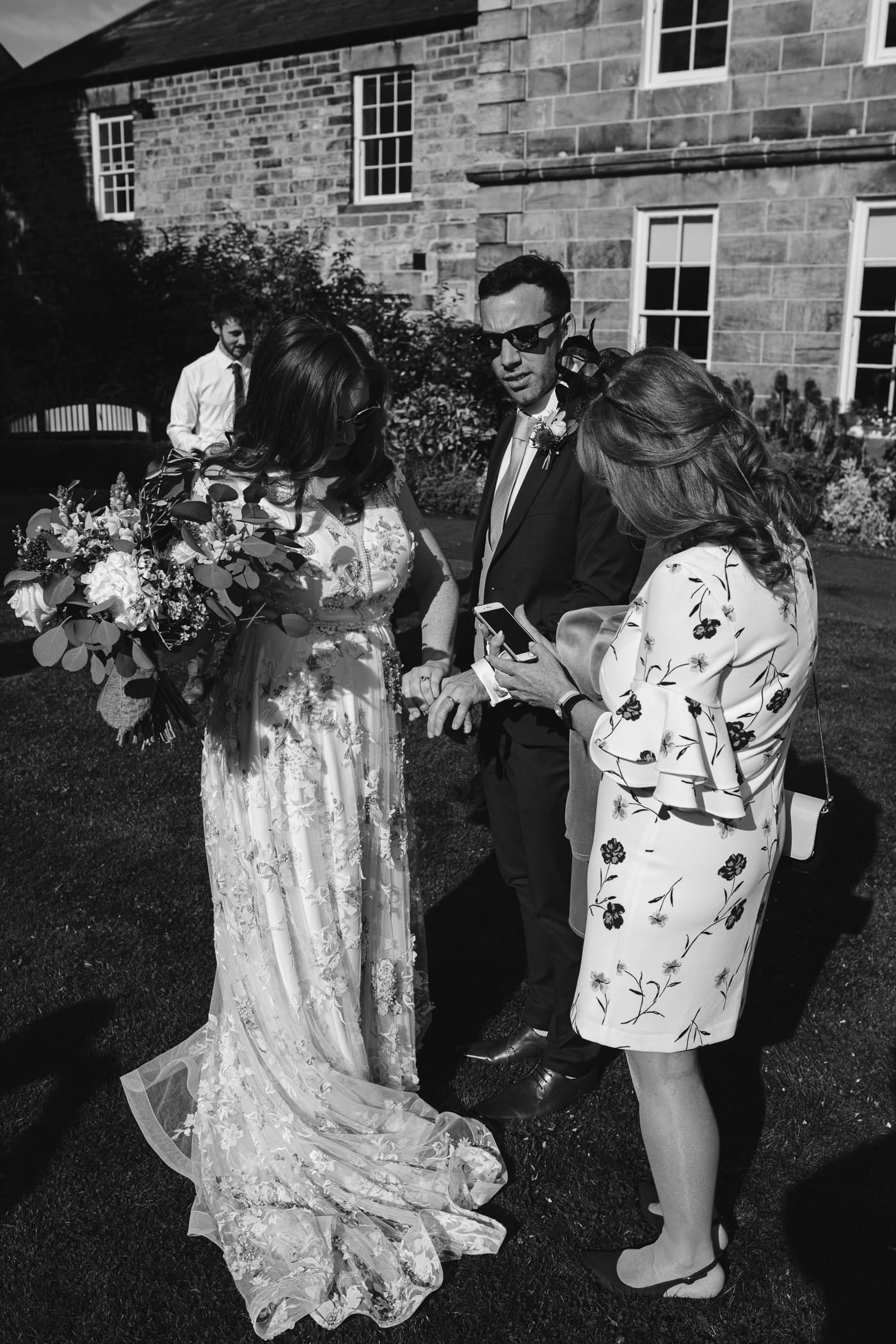 Hexham House Wedding - A beautiful black and white photo capturing a bride and groom in front of a charming house.