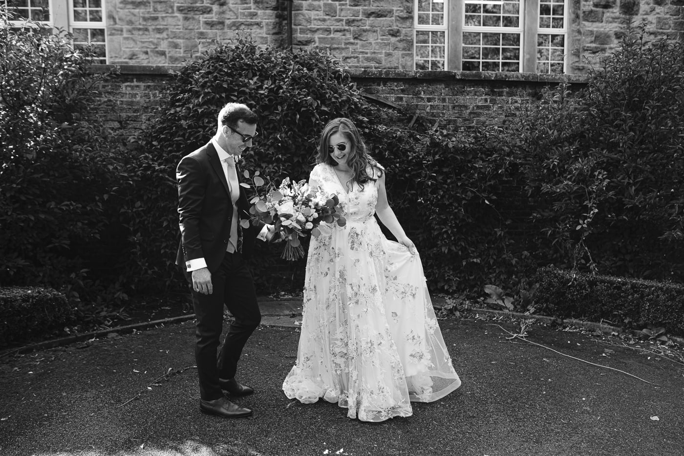 A Hexham House Wedding: A bride and groom standing in front of a brick building.
