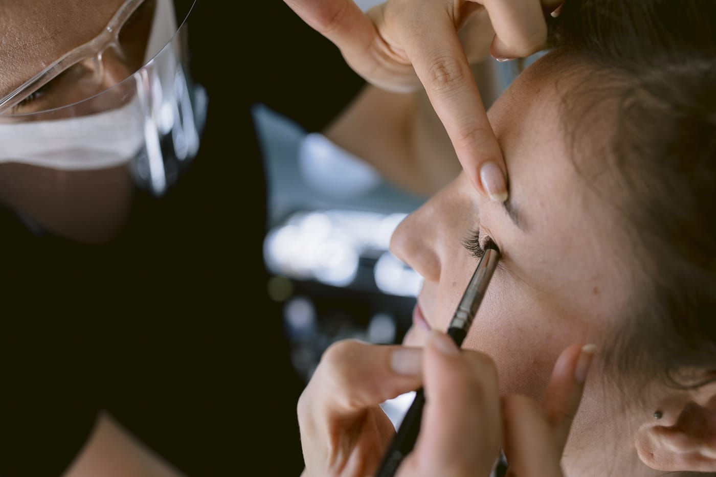 A woman at Hexham House getting her eyebrows done by a makeup artist for her wedding.