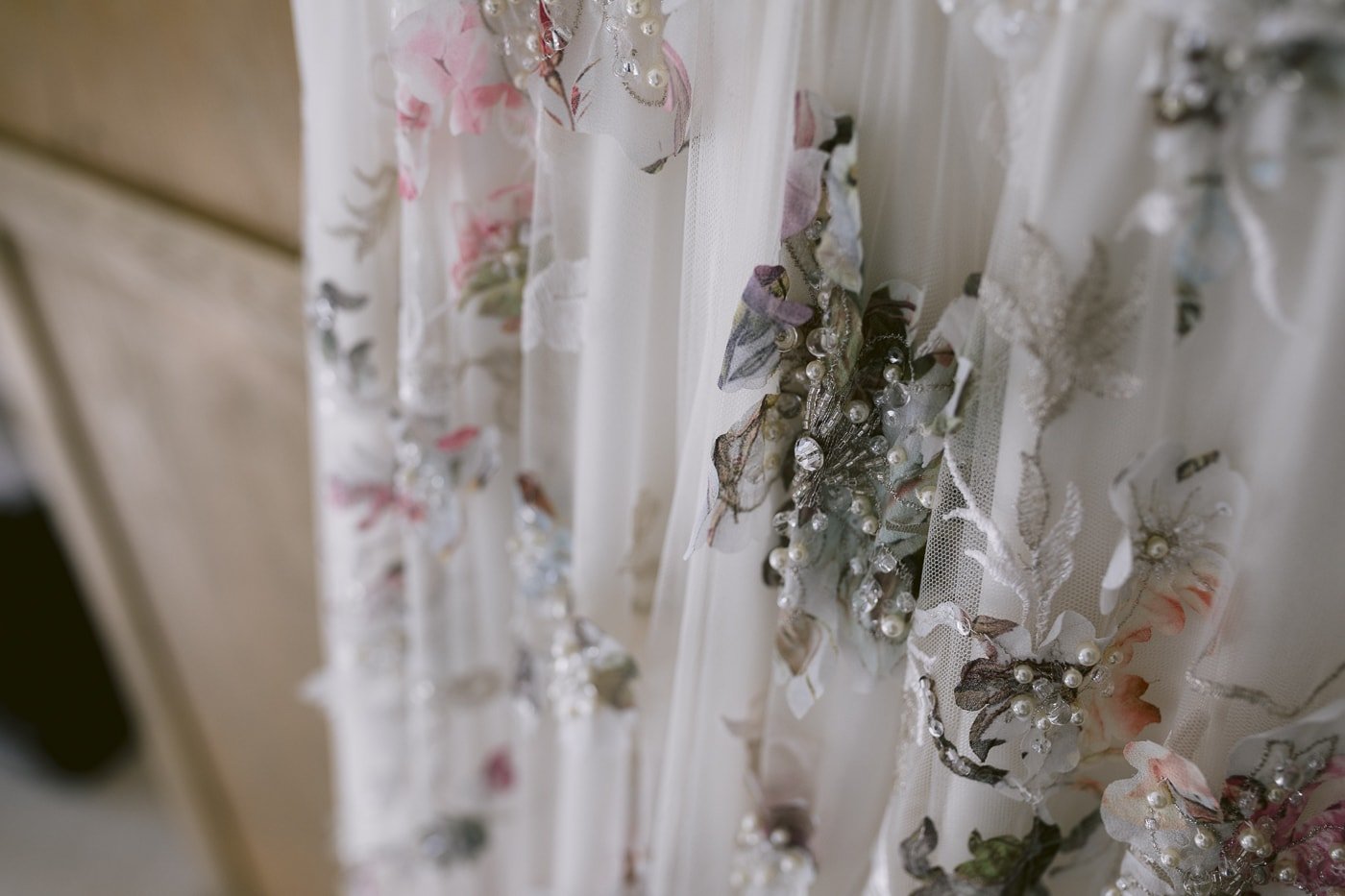 A close up of a Hexham House wedding dress adorned with flowers.
