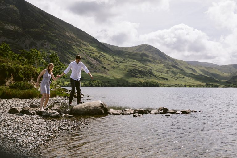 A Lake District couple standing on rocks near a lake during their Civil Partnership ceremony.