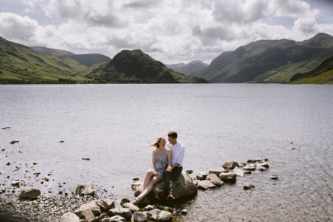 A couple enjoys their engagement session near a lake in the Lake District.