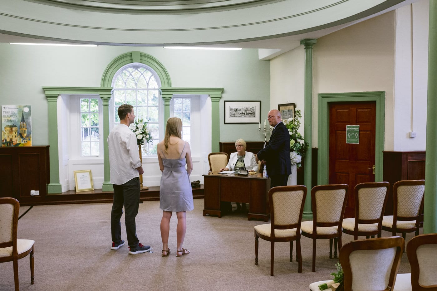A man and woman standing in a room with a civil partnership ceremony.