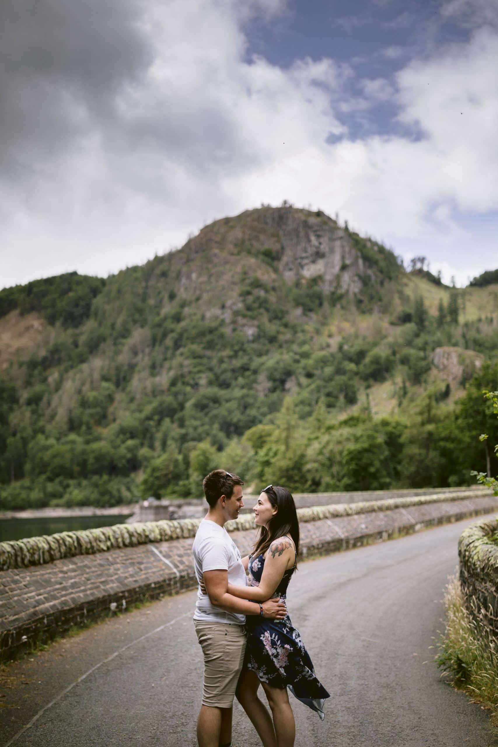 A couple embracing on a road near a lake during their Portrait Session.