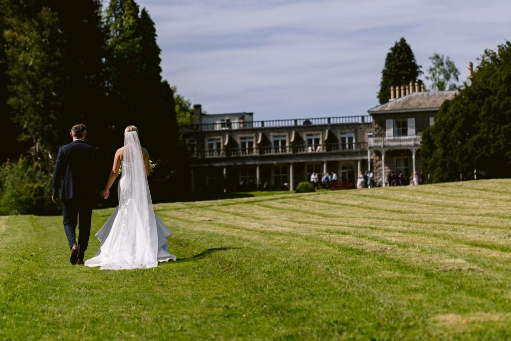 Bride and Groom walking on the grounds of Leeming House