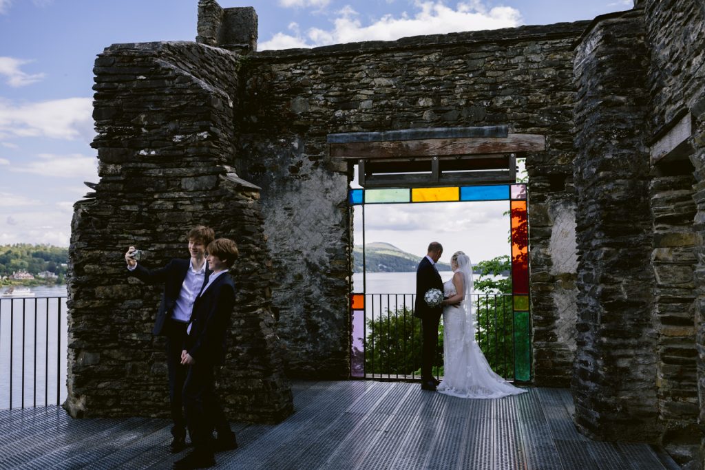 A bride and groom elopement picture in front of a stained glass window at Briery Wood Country House.