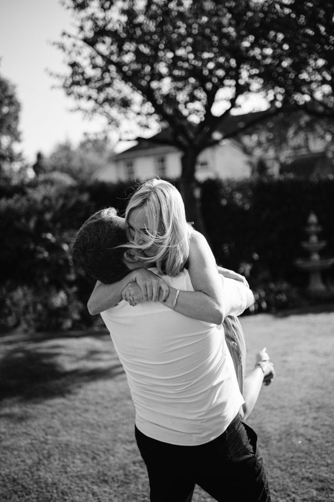 Black and white photo of a man hugging a woman.