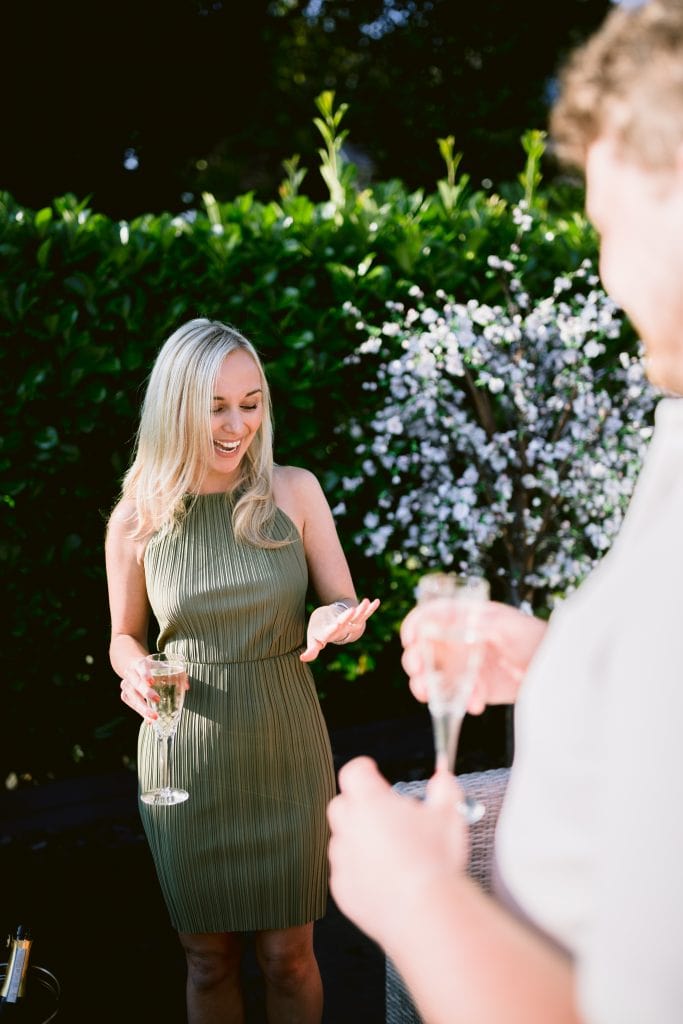 A man and woman are drinking champagne at an outdoor party.