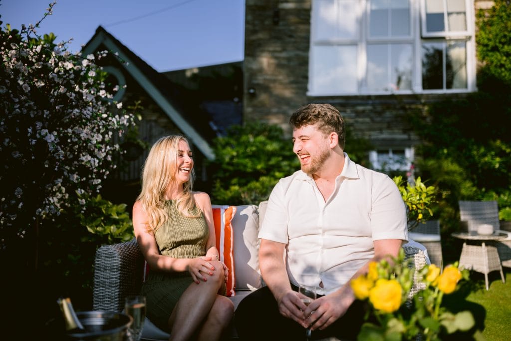 A man and woman sitting on a chair in a garden.