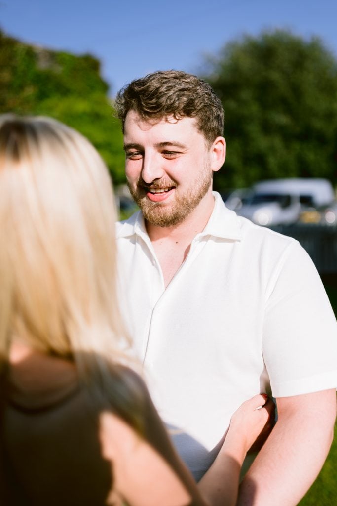 A man and woman are smiling at each other in a park.