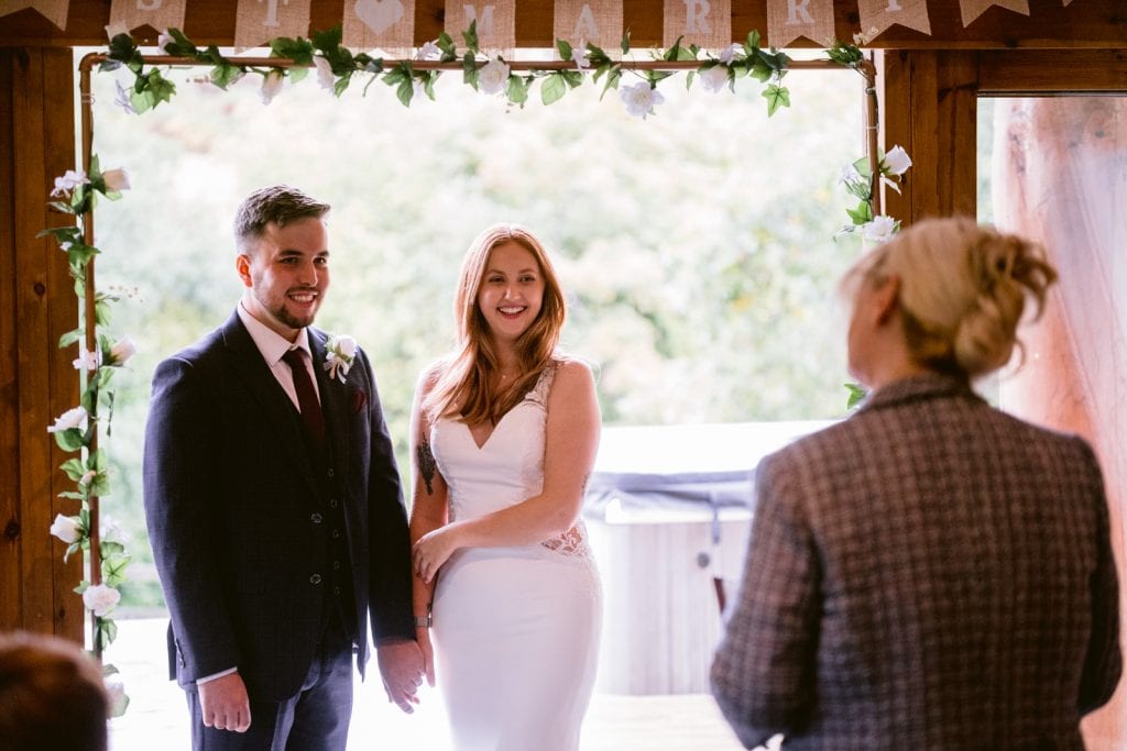 A bride and groom smiling at each other during their Autumn Elopement at Hidden River Cabins.