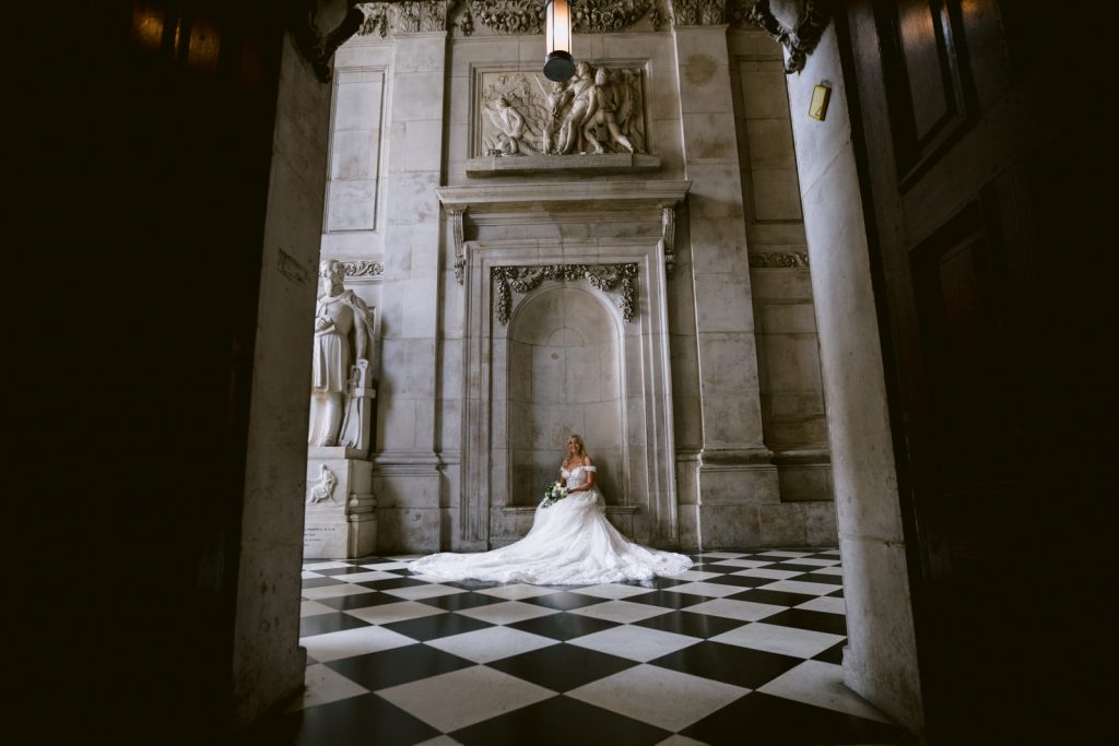 A bride in a wedding dress standing in the ornate doorway of St Paul's Cathedral.