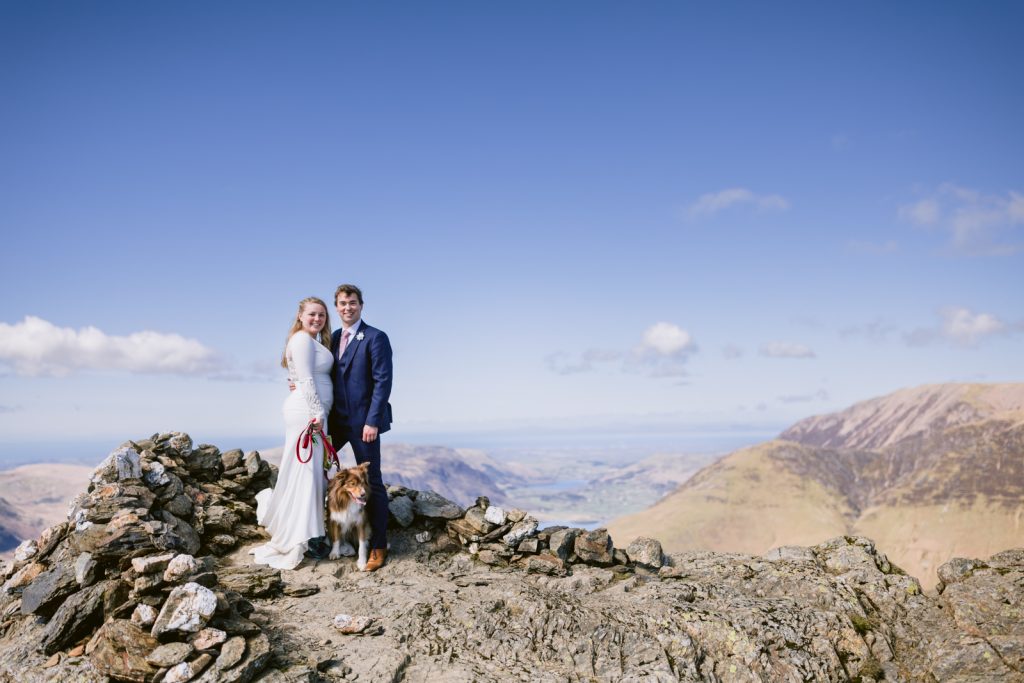 A bride and groom enjoying a wedding portrait session on top of Buttermere mountain, with their dog joining them for an adventurous hike.