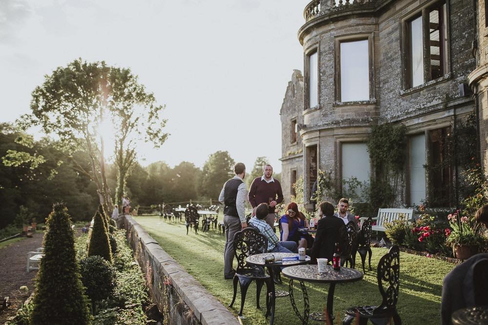 A group of people gathering in the garden of a castle, which is one of the most beautiful Carlisle wedding venues.