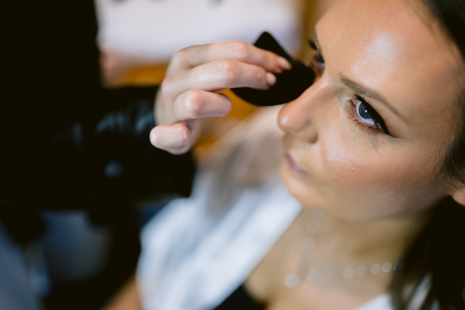 A woman is getting her makeup done by a makeup artist at Ruleholme.