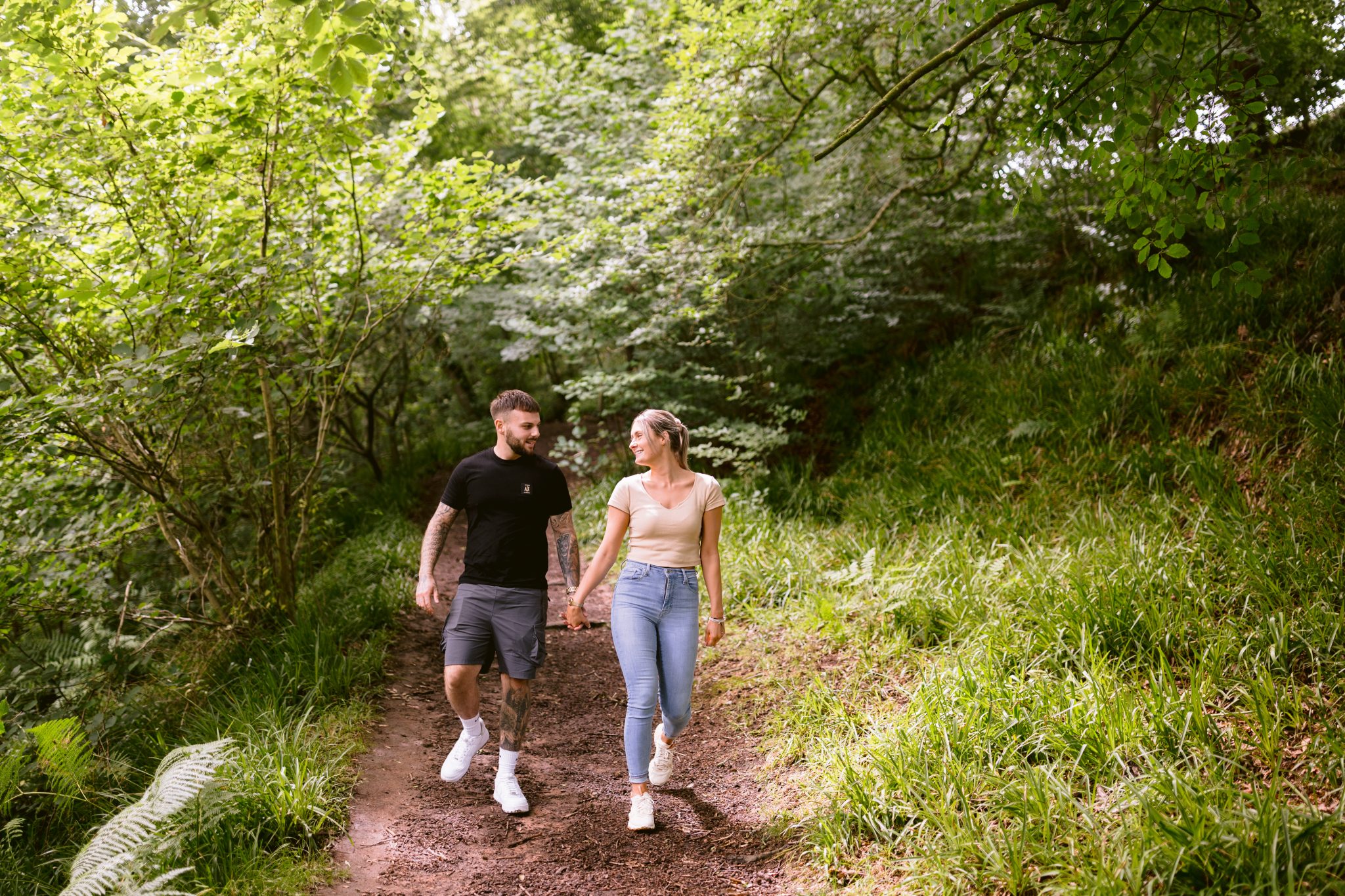 A Wood couple walking down a trail in the woods.