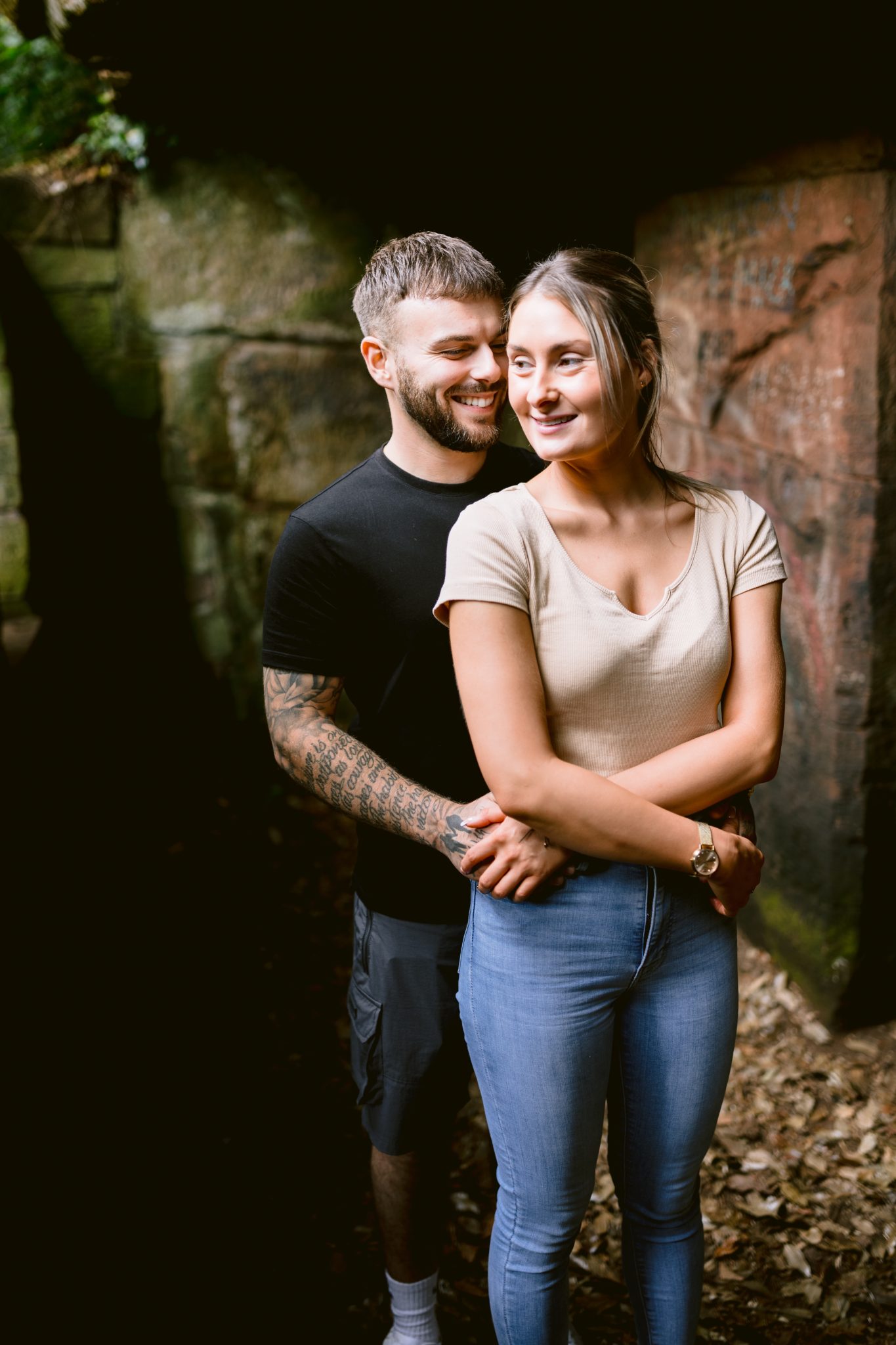A wood couple embracing in a cave during their engagement session.