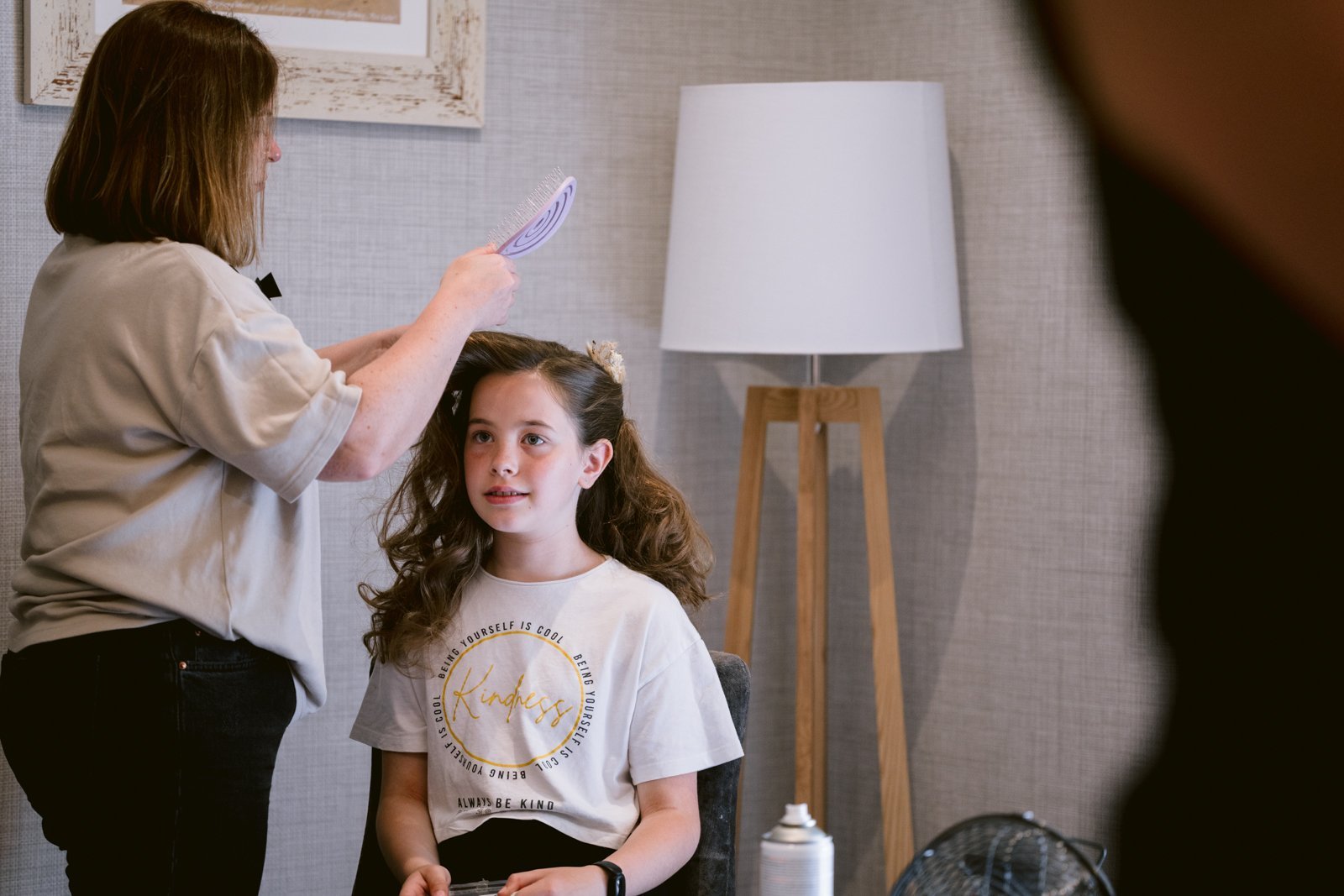 A young girl getting pampered by a hairdresser before her big day at Gretna Hall Wedding.