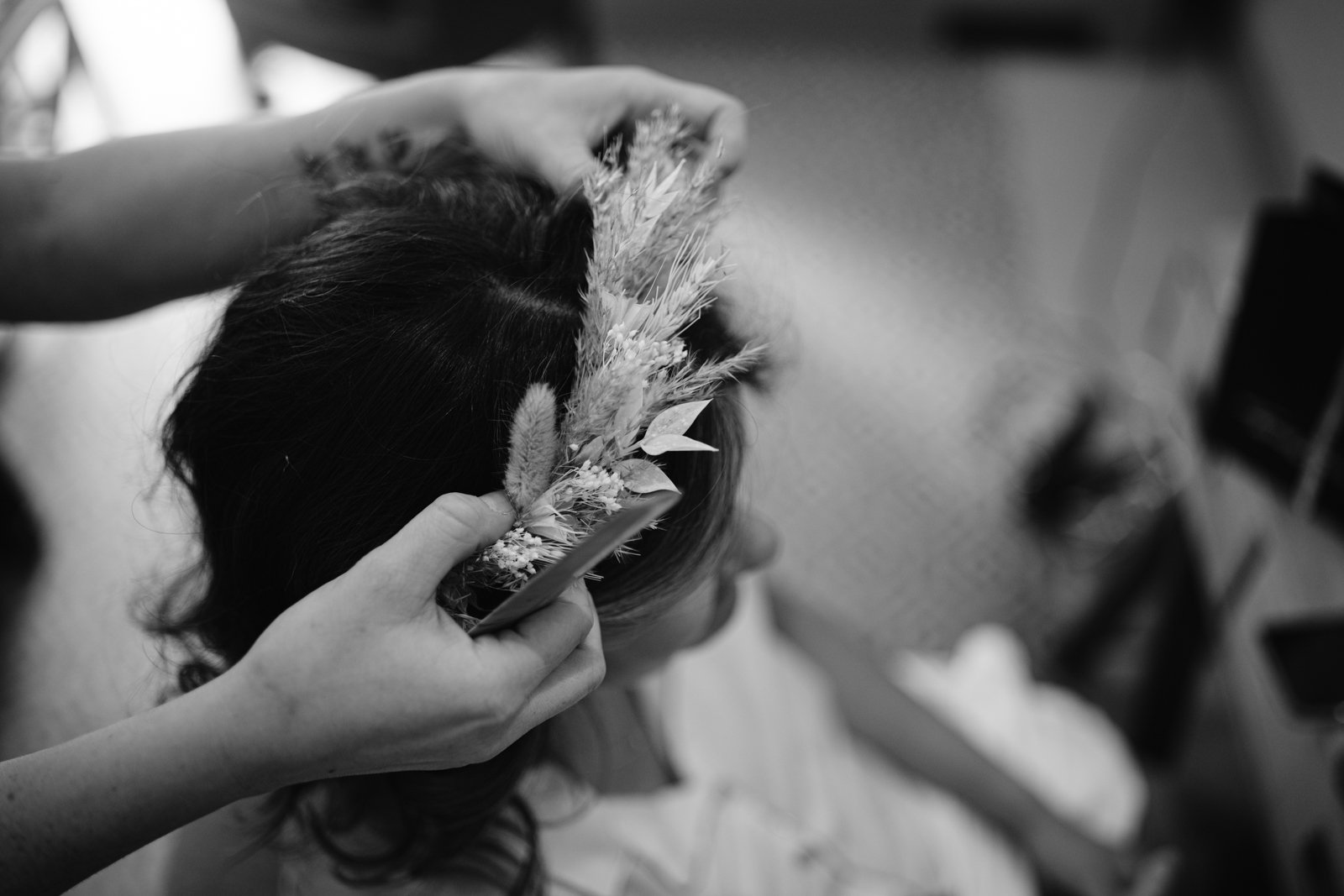 In a vintage black and white photo, a woman is getting her hair styled at Gretna Hall Wedding.