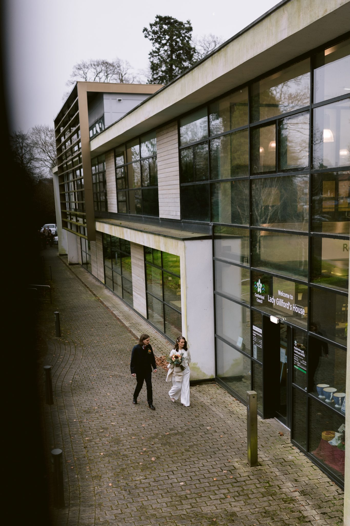 A winter wedding, with the bride and groom walking in front of Lady Gillford's house.