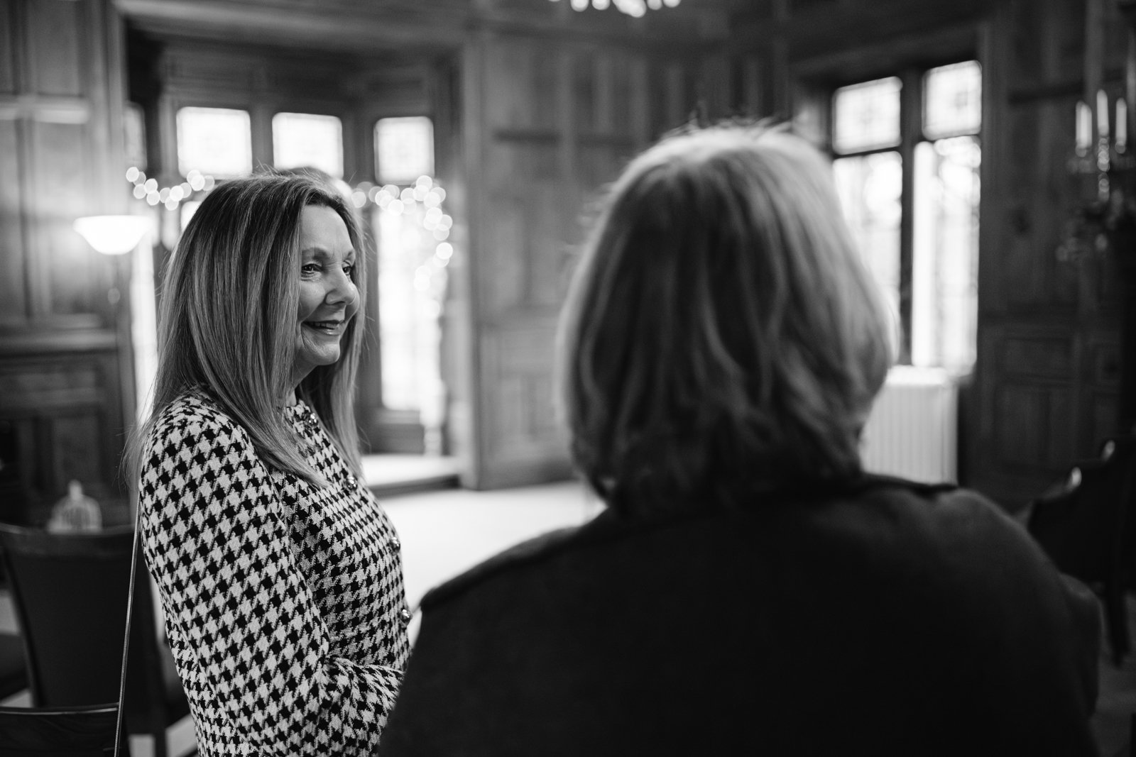 A black and white photo of two women talking in Lady Gillford's house.