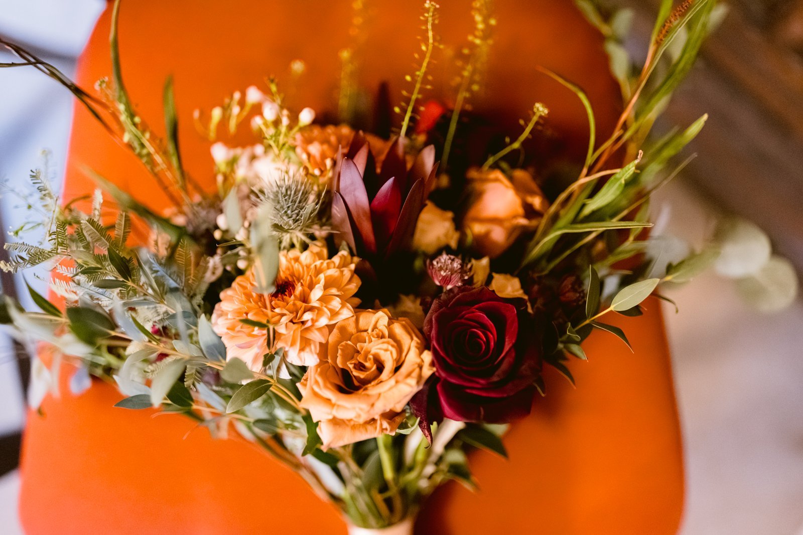 A bouquet of flowers sitting on an orange chair at Lady Gillford's House.