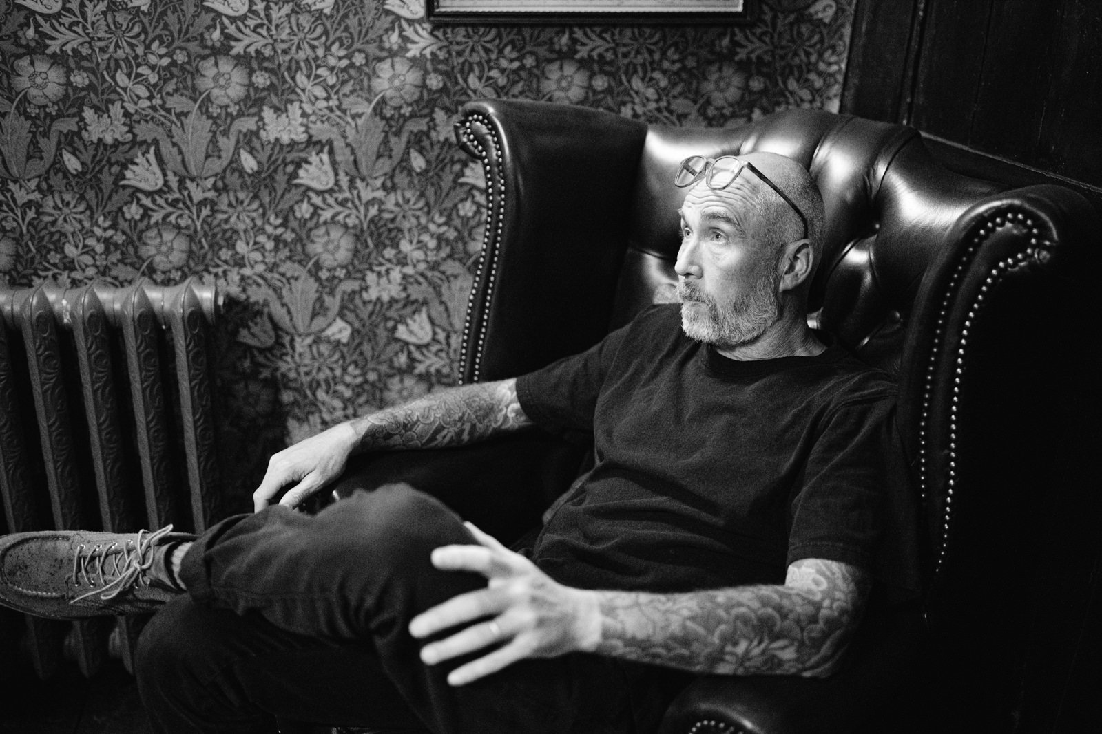 A black and white photo of a man sitting in a chair at Yew Tree Farm.