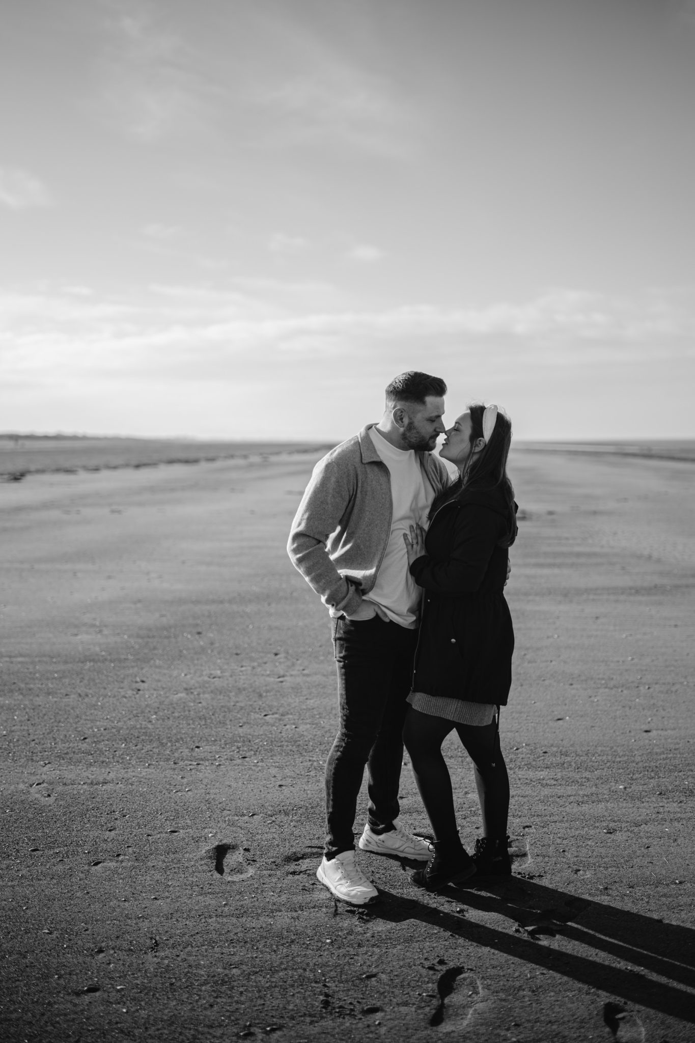 A couple sharing an affectionate moment during their Portrait Session on an open, empty road.