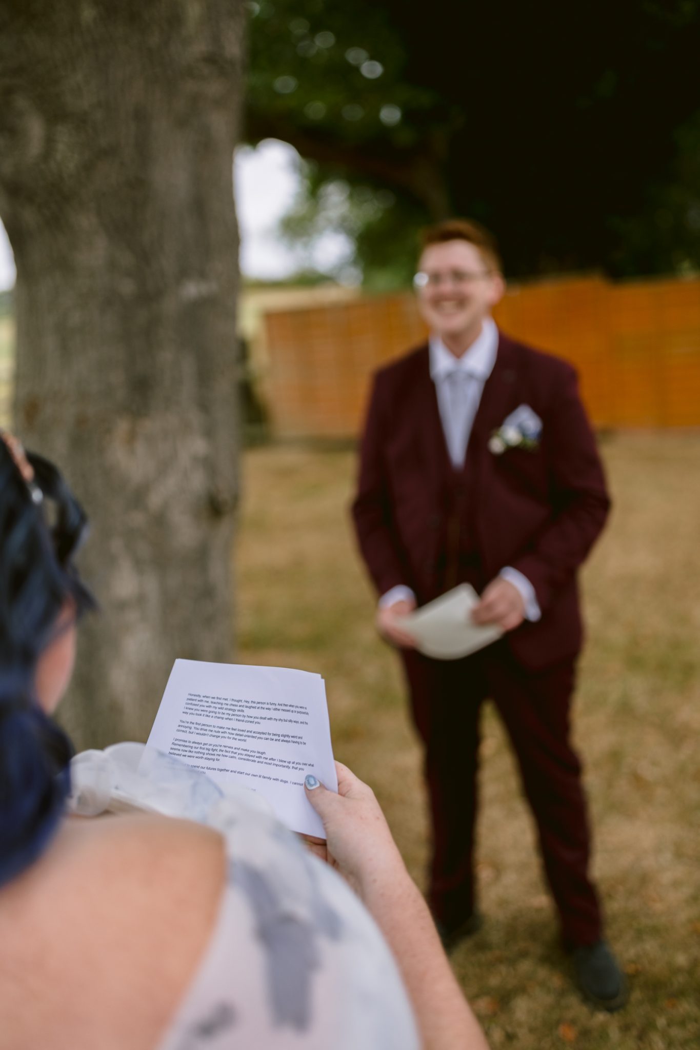 A woman holding a piece of paper at a rustic farm wedding in Shrewsbury, capturing the charm and warmth of an LGBT+ friendly celebration.