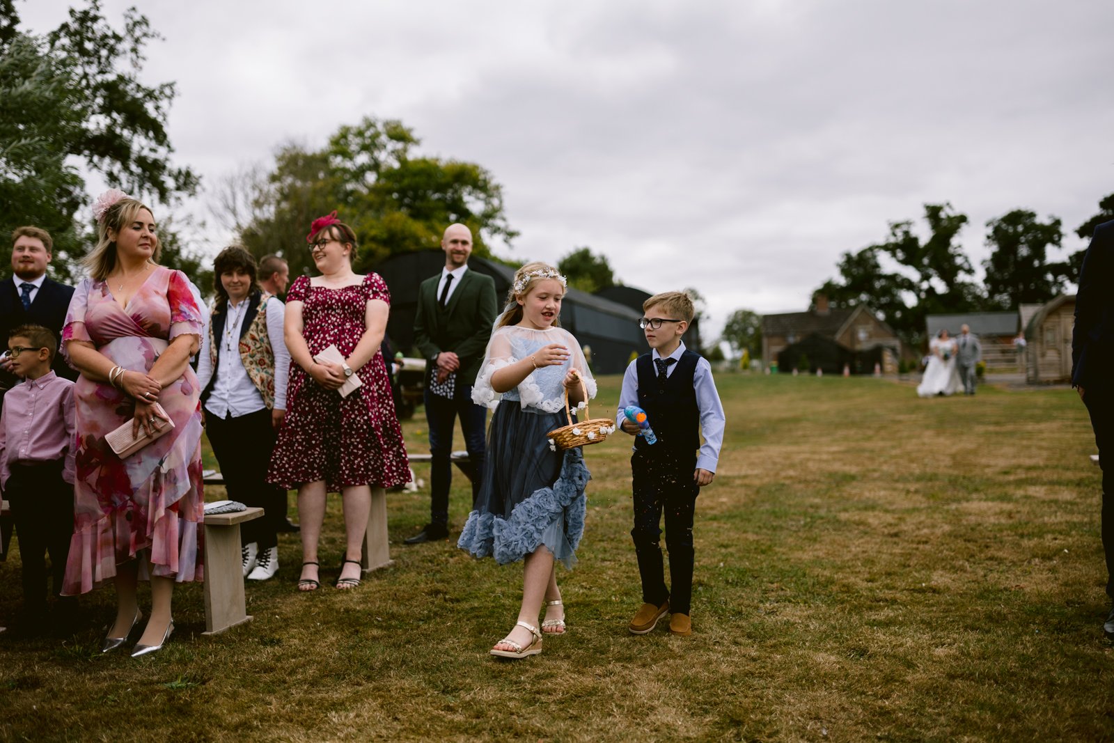 A group of people outside enjoying a rustic farm wedding, celebrating love in a charming countryside setting.