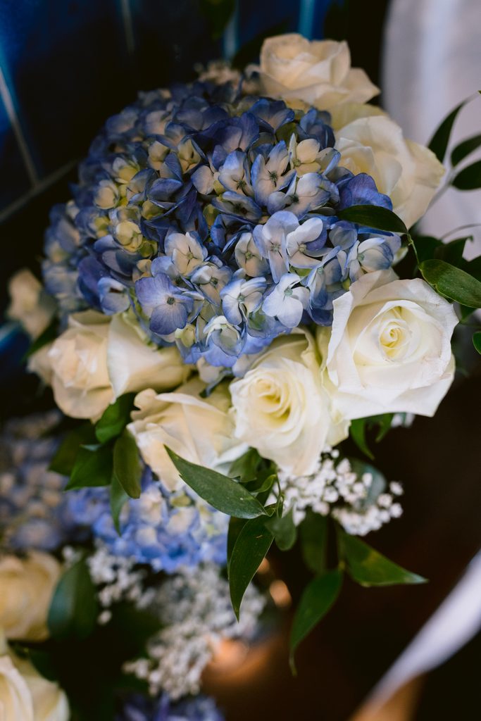 A bouquet inspired by Padley Gorge, featuring blue hydrangeas, white roses, and green leaves with small white filler flowers—perfect for a late summer wedding.