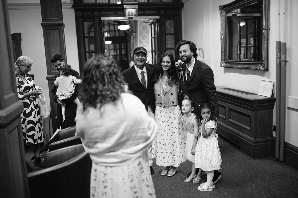 A group of adults and children posing for a photo in a Sheffield Town Hall wedding corridor.